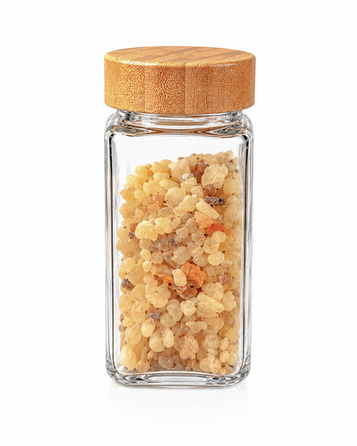 Classic Omani frankincense resin in a clear glass jar with bamboo lid