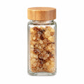 Traditional Omani frankincense resin in a clear glass jar with bamboo lid