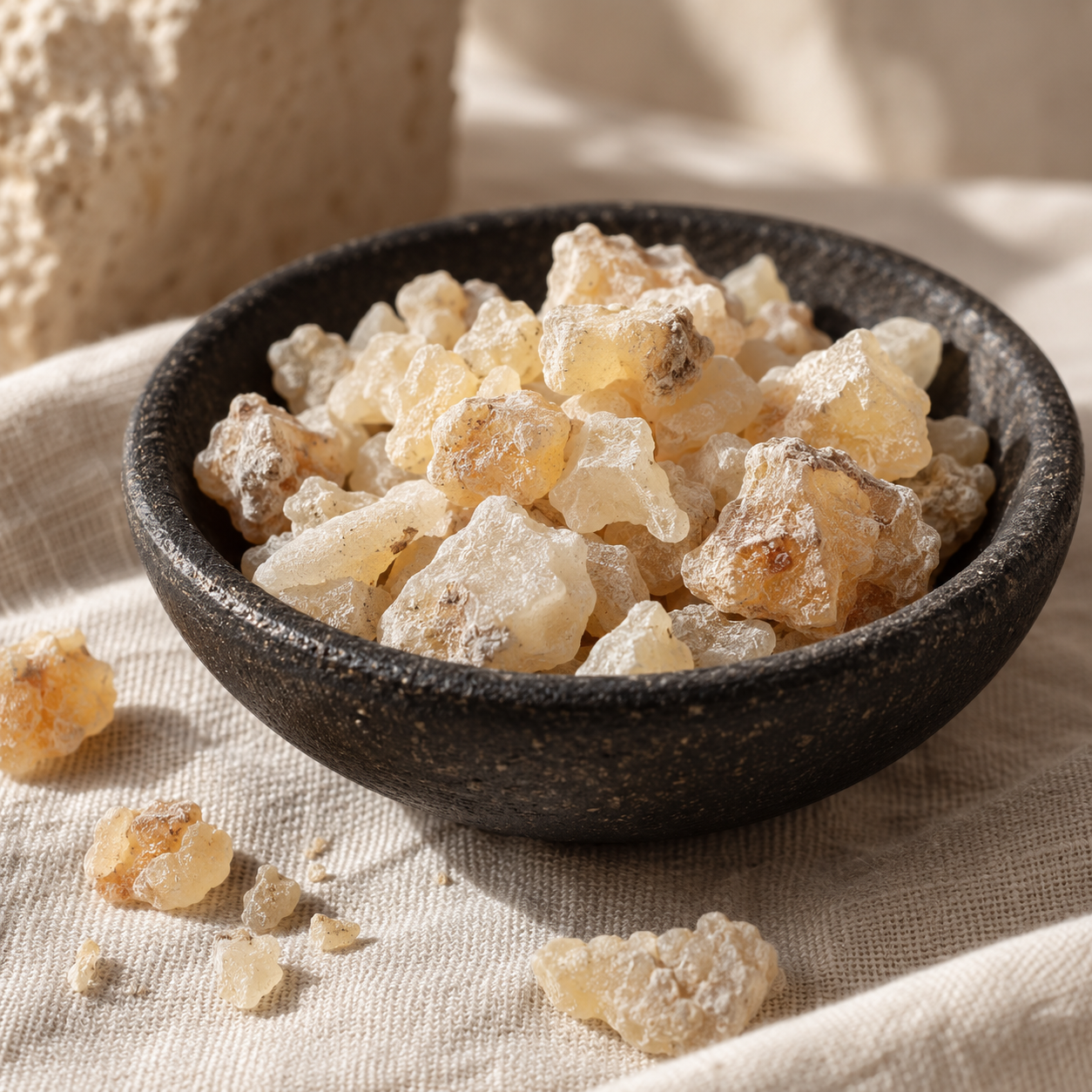 Irregular pale frankincense tears in a black stoneware bowl